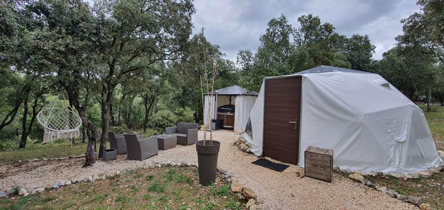Dôme blanc avec porte en bois et espace lounge extérieur privatif à l'Astronarium, près de Montpellier