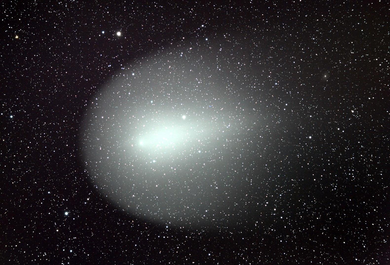 Comète lumineuse à coma verdâtre photographiée depuis l'observatoire Astronarium, ciel étoilé profond